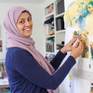 Artist Bushra Gill standing in front of her work